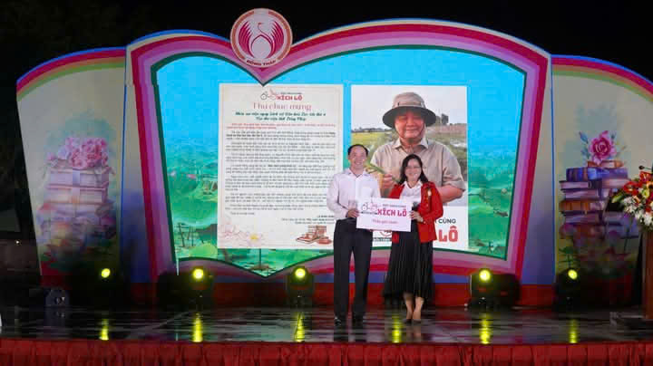 Bà Huỳnh Thị Hoài Thu trao bảng tượng trưng tặng sách do Ông Lê Minh Hoan  gửi tặng Thư viện Tỉnh